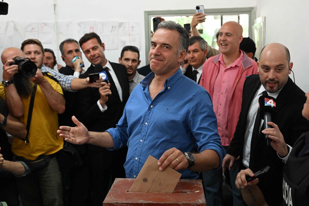 Projeções apontam para segundo turno entre esquerda e centro-direita na eleição presidencial no Uruguai 1 Yamandú Orsi, candidato da Frente Ampla à Presidência do Uruguai, vota no departamento de Canelones — Foto: Eitan ABRAMOVICH / AFP