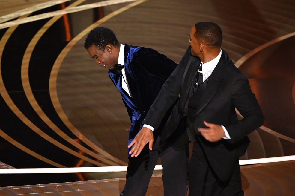 O ator Will Smith dá um tapa no ator Chris Rock durante a 94ª premiação do Oscar, em Hollywood, Califórnia, em 27 de março. — Foto: Robyn Beck / AFP