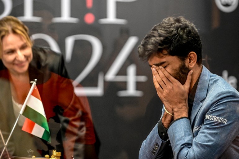 O grande mestre da Índia, Gukesh Dommaraju (R), reage após vencer o grande mestre de xadrez da China, Ding Liren, no jogo 14 do Campeonato Mundial FIDE de 2024, em Cingapura, em 12 de dezembro de 2024.