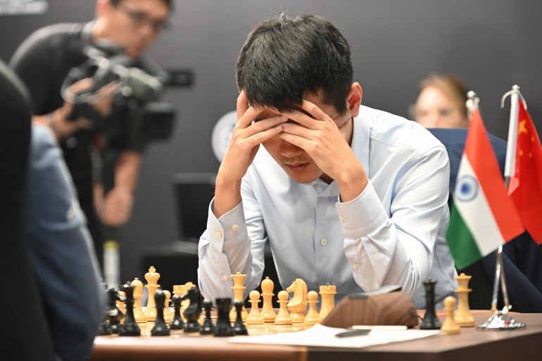 O grande mestre de xadrez da China, Ding Liren, compete contra o grande mestre da Índia, Gukesh Dommaraju, durante o jogo 14 do Campeonato Mundial FIDE de 2024, em Cingapura, em 12 de dezembro de 2024.