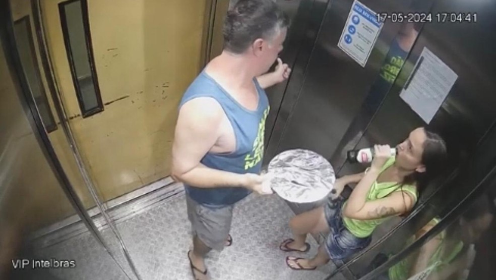 Luiz Marcelo Antonio Ormond segurando brigadeirão no elevador, ao lado da namorada Júlia Andrade Cathermol Pimenta, suspeita de envenená-lo — Foto: Reprodução