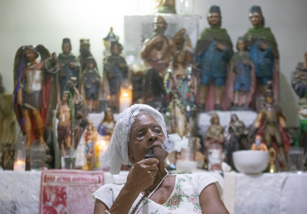 Iraci Cardoso dos Santos Lino, conhecida como Tia Ira, rezadeira de 87 anos nascida e criada no Morro da Serrinha, em Madureira, herdou o dom de sua Mãe e de sua avó, Maria Joana. Fotos para a reportagem: "Cada vez mais raras, rezadeiras resistem e lutam por tradição" — Foto: Domingos Peixoto / agência Globo