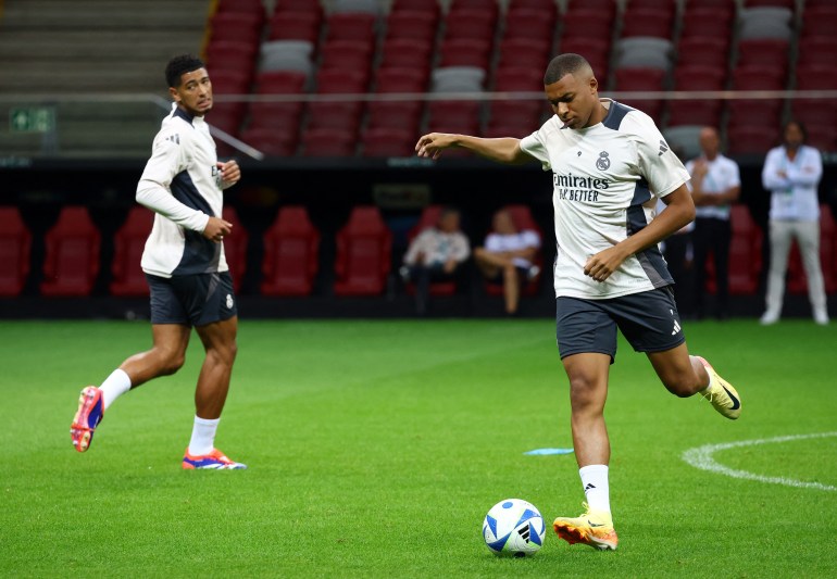 Futebol Futebol - Supertaça Europeia - Treino do Real Madrid - Estádio Nacional, Varsóvia, Polónia - 13 de agosto de 2024 Kylian Mbappe do Real Madrid enquanto Jude Bellingham observa durante o treino REUTERS/Kacper Pempel