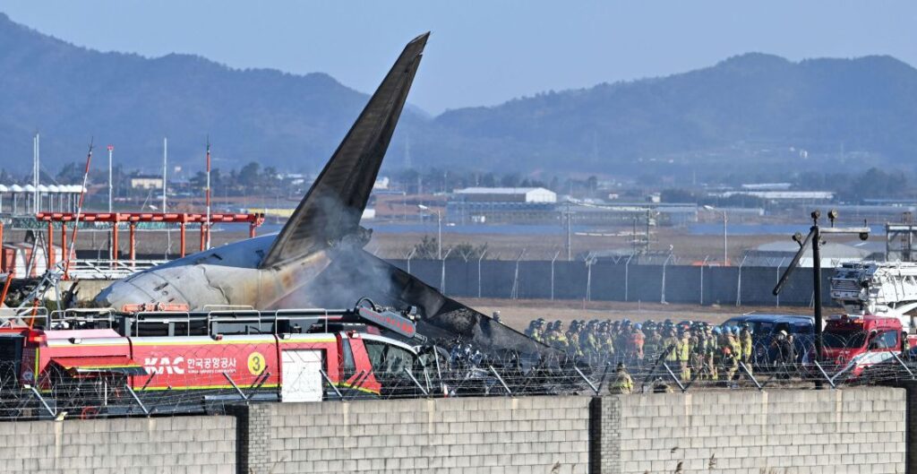 Bombeiros e membros da equipe de resgate trabalham na pista do Aeroporto Internacional de Muan em Muan, Coreia do Sul, domingo, 29 de dezembro de 2024. (Lee Young-ju/Newsis via AP)