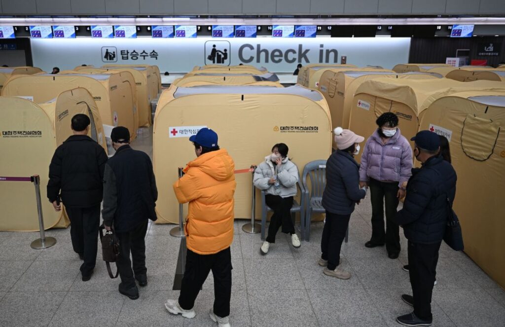 Parentes das vítimas do acidente aéreo mortal em Jeju se reúnem em um abrigo improvisado no Aeroporto Internacional de Muan em 30 de dezembro.