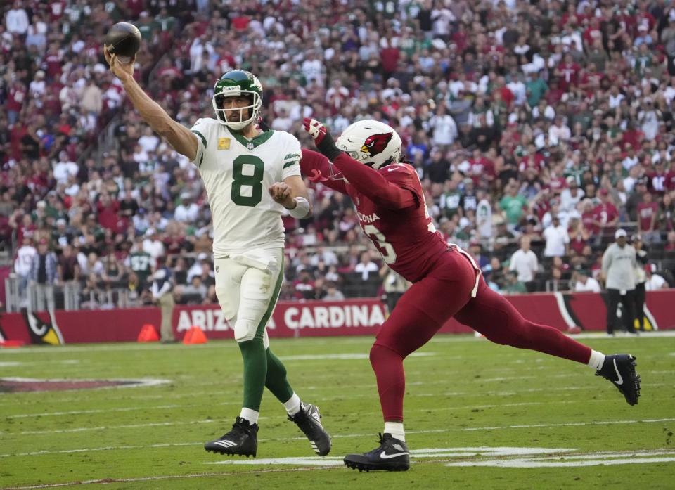 O quarterback do New York Jets, Aaron Rodgers (8), arremessa enquanto é pressionado pelo linebacker do Arizona Cardinals, Baron Browning (53), durante o primeiro quarto no State Farm Stadium em 10 de novembro de 2024, em Glendale.