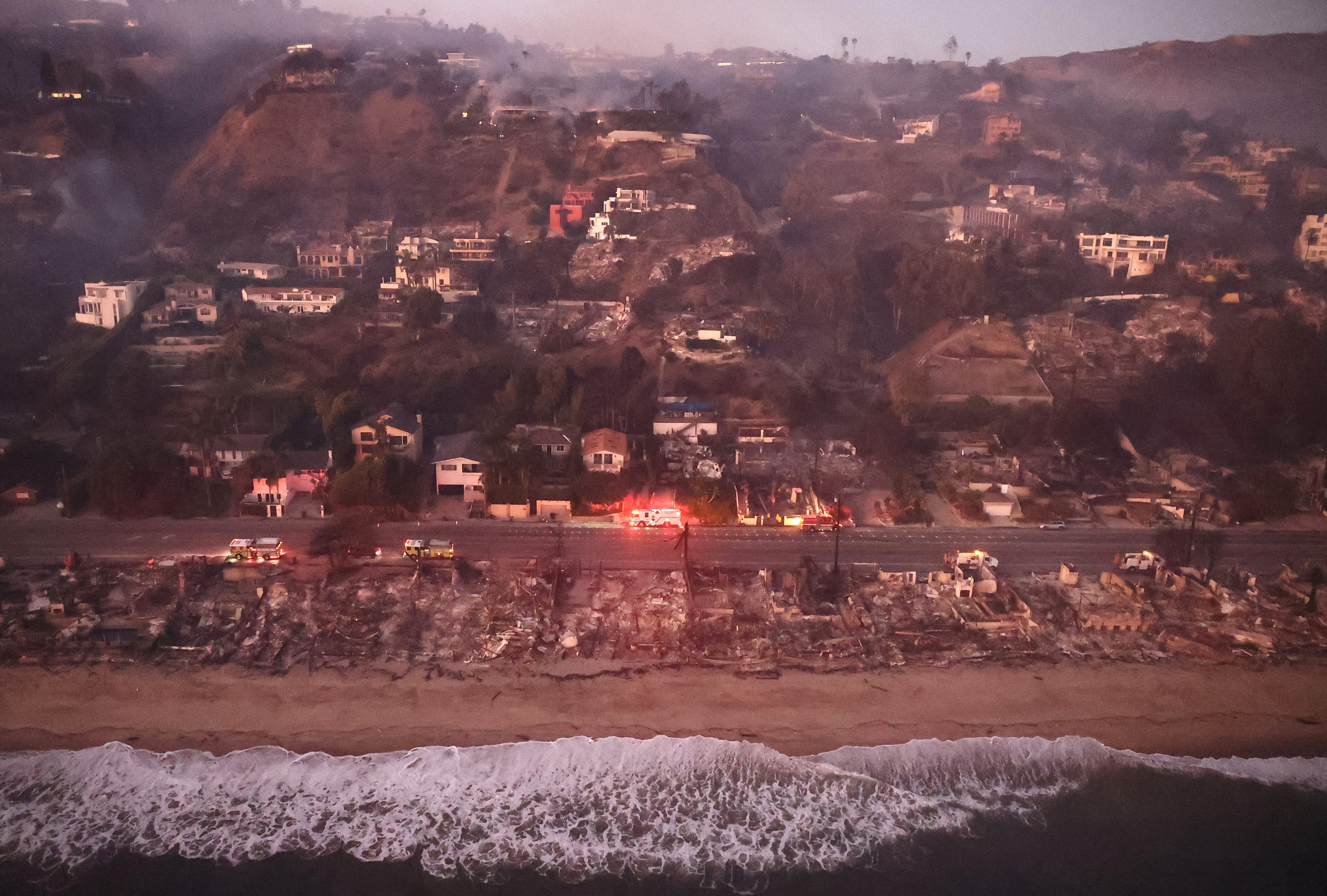 Vista aérea de casas danificadas pelo fogo ao longo de uma praia em Malibu, Califórnia.