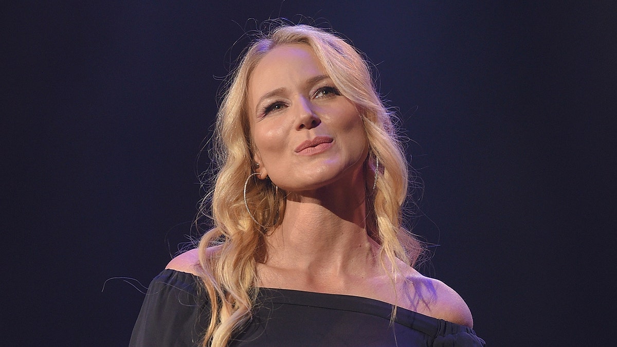 Jewel defende o desempenho da bola de RFK Jr. MAHA, diz que a administração Trump está disposta a ajudar na crise de saúde mental 1 A cantora Jewel usa um vestido cinza com ombros largos durante um show.