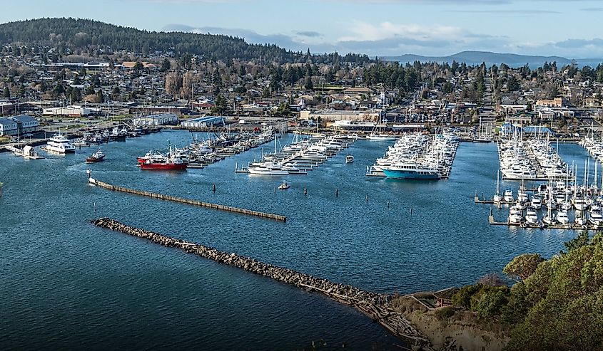 8 cidades em Washington que o transportam para o passado 7 Barcos ancorados na marina com a área residencial costeira em Anacortes, Washington.