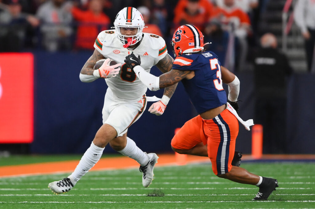 O tight end do Miami Hurricanes, Elijah Arroyo (8), corre com a bola após uma recepção contra o defensor do Syracuse Orange, Clarence Lewis (3), no JMA Wireless Dome.