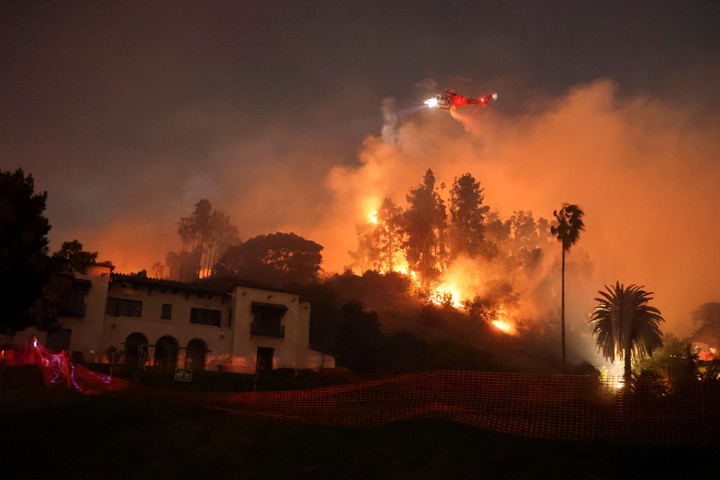 As chamas perseguem uma mansão nas colinas que cercam Hollywood. Foto: Reuters