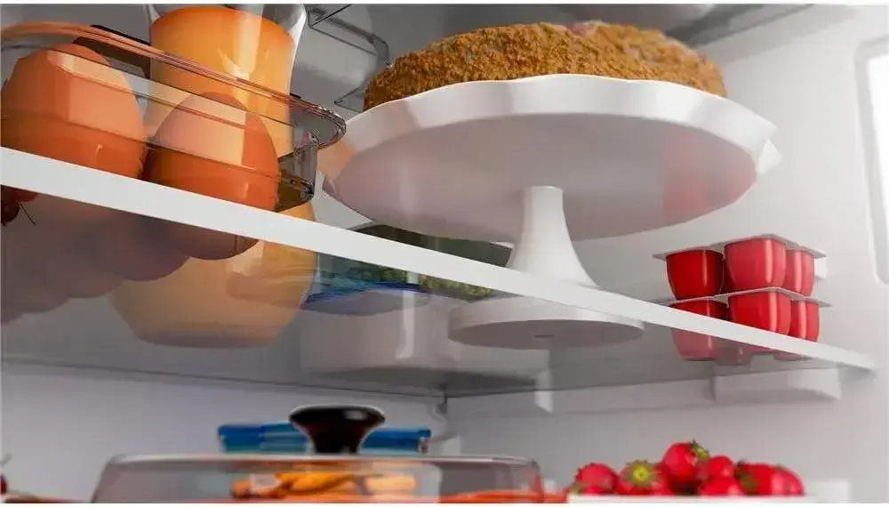 Interior de uma geladeira em 3D com prateleiras brancas e elementos organizados.